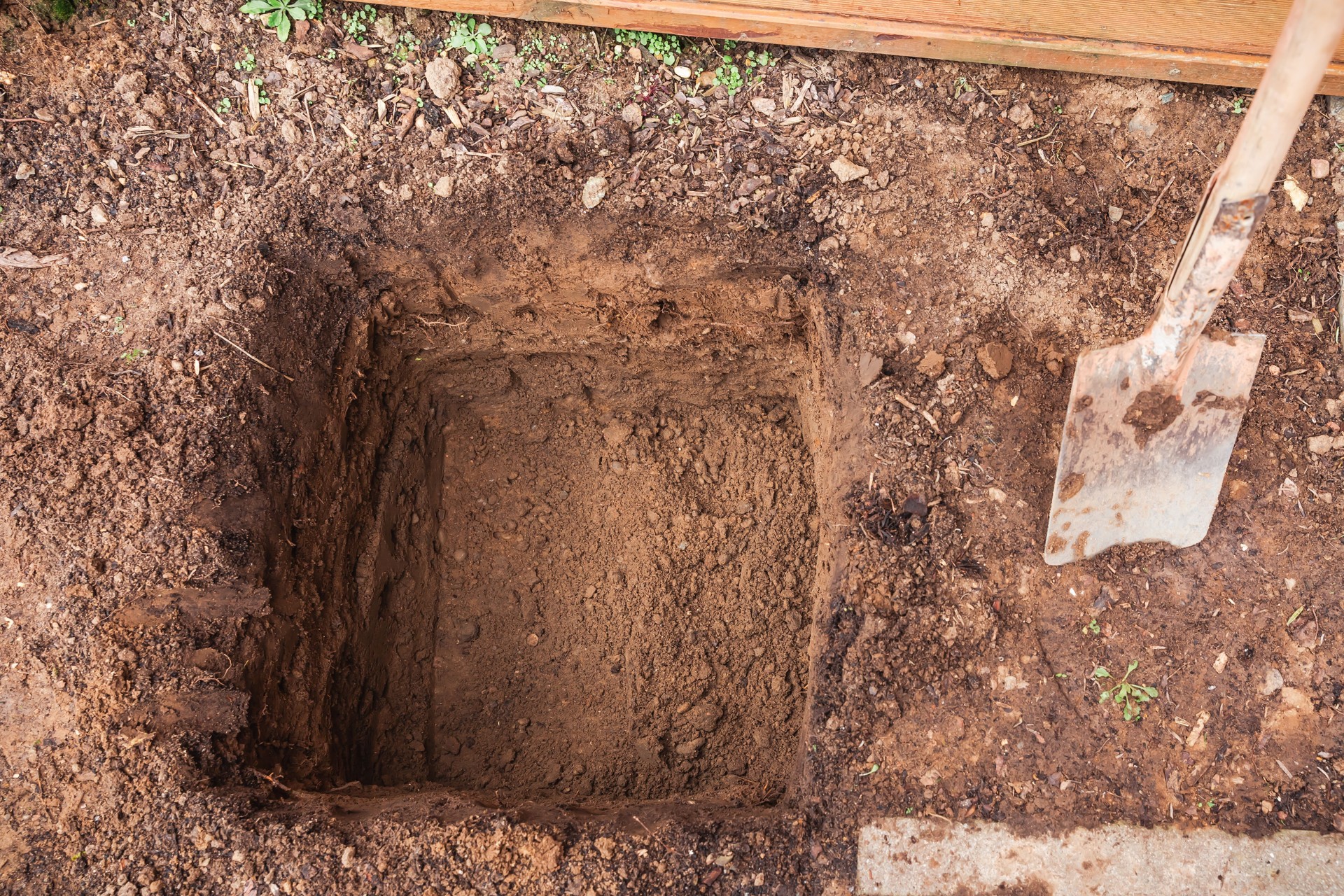 Hole in a soil, prepared for planting or construction, pit in a ground with shovel